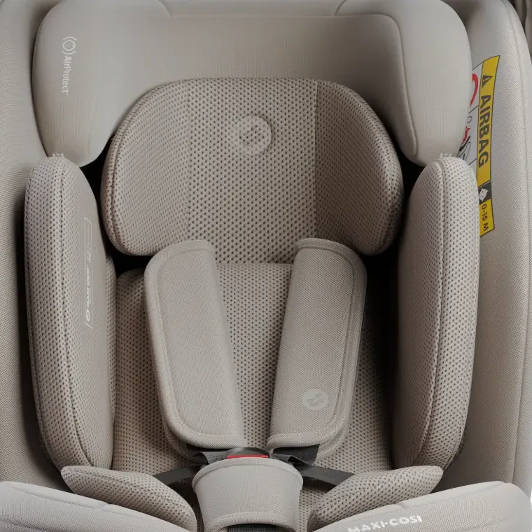 Close-up render of the car seat's beige mesh headrest, side wings and harness pads.
